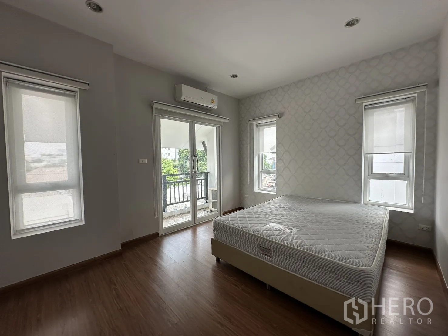 Home Office for rent in Watthana, Bangkok - Bright master bedroom featuring wood floors, multiple windows and balcony access.