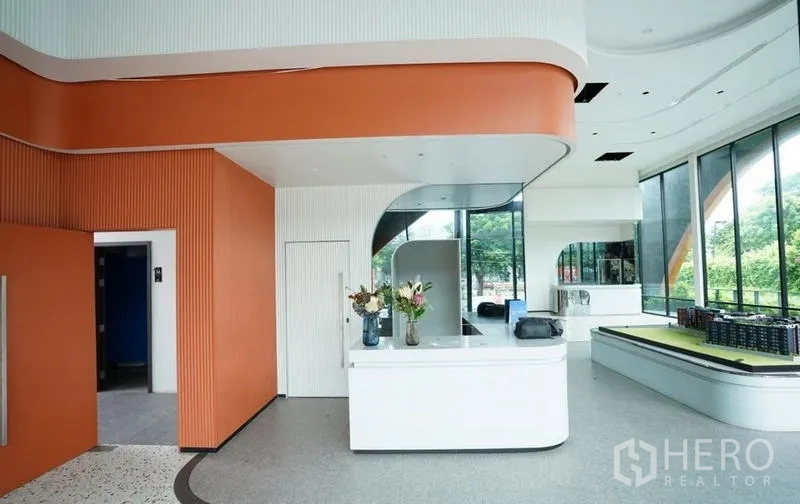 独立商业地产 出租在Bang Na, Bangkok - 接待区橙色天花装饰与白色柜台，临街玻璃大堂。