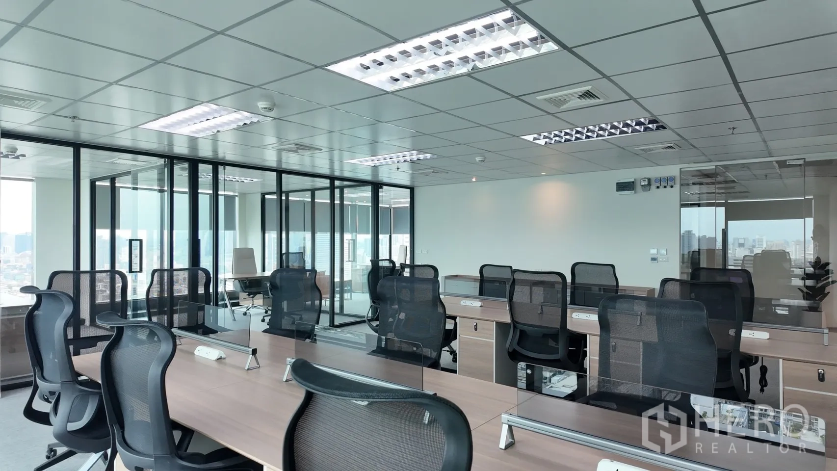 办公室 for rent in Din Daeng, Bangkok - 宽敞办公楼层配共享工位、地毯与吊顶照明，旁有玻璃会议室。