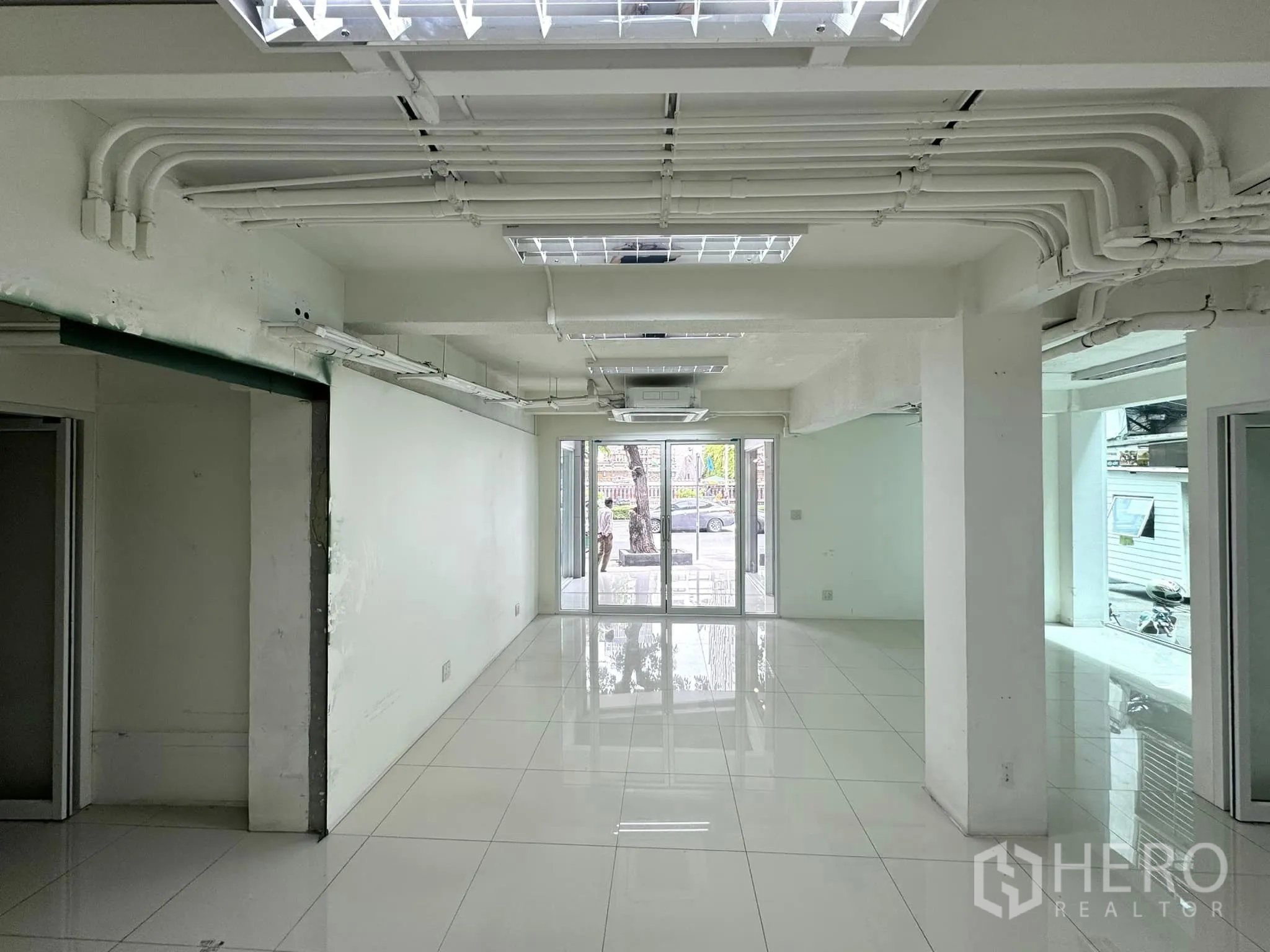 零售空间 出租在Bang Rak, Bangkok - 细长型展售区，外露天花管线，玻璃入口面向街道。