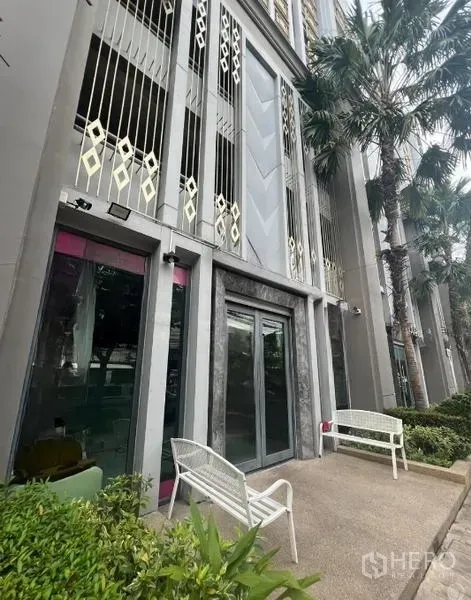 零售空间 出租在Khlong Toei, Bangkok - 一层店面玻璃立面，户外座位与装饰金属格栅，绿意环绕的素坤逸商圈位置。