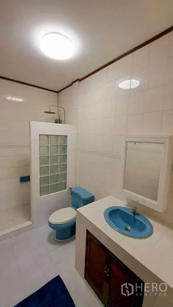 ทาวน์เฮาส์ ให้เช่าในWatthana, Bangkok - ห้องน้ำกระเบื้องขาว อ่างล้างหน้าและโถสุขภัณฑ์สีน้ำเงิน กั้นอาบน้ำบล็อกแก้ว