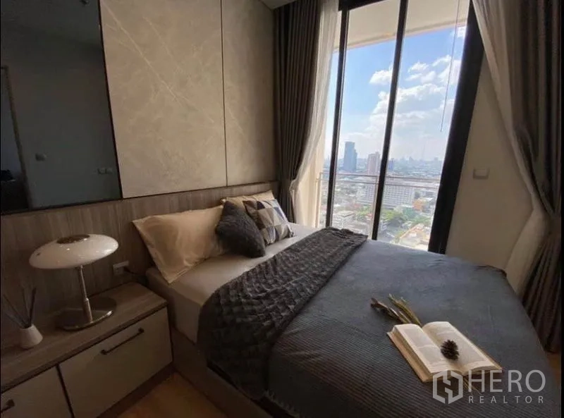 公寓 出租或出售在Phaya Thai, Bangkok - 转角卧室，通过高窗可观曼谷全景天际线。