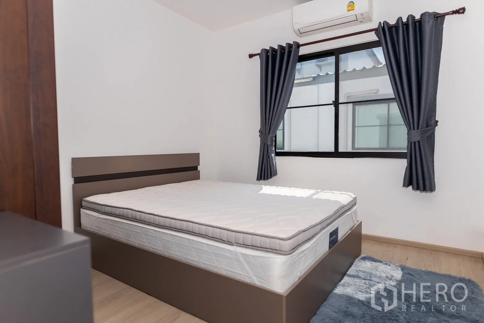 Townhouse for rent in Bang Phli, Samut Prakan - Cozy bedroom with queen bed, dark curtains, and soft rug.