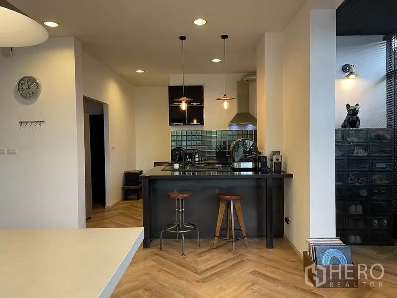 บ้าน ขายในSai Mai, Bangkok - ห้องครัวโทนดำพร้อมไอส์แลนด์ เก้าอี้สตูล ผนังกระเบื้อง และไฟแขวน