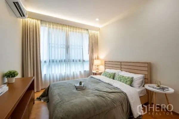 公寓 出售 - 温馨卧室，双人床、柔和灯光和大窗帘窗。