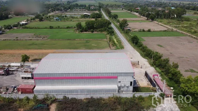 货栈 出售在Lam Luk Ka, Pathum Thani - 航拍：带围墙的仓库园区，周围是田野与通行道路