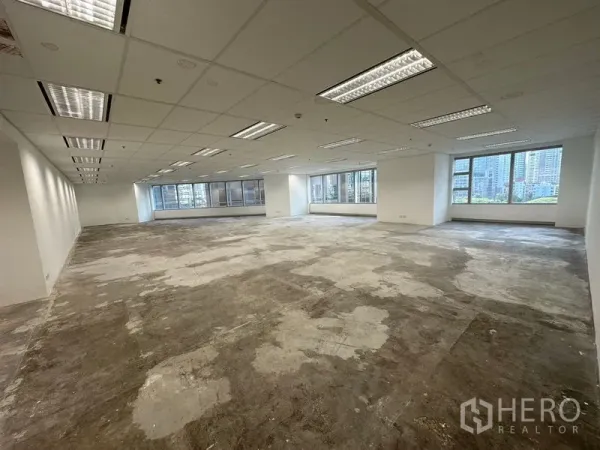 办公空间 出租 - 大面积开放式办公楼层，未铺设混凝土地面，网格吊顶照明，宽窗可望城市景观。