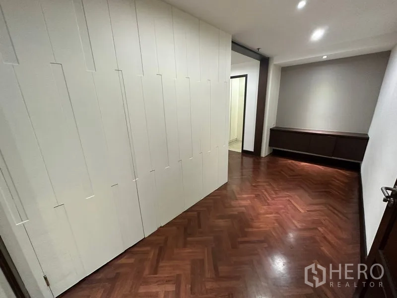 คอนโด ให้เช่าในWatthana, Bangkok - โถงทางเข้าพร้อมผนังแผงสีขาวและพื้นไม้ปาร์เกต์ลายก้างปลา