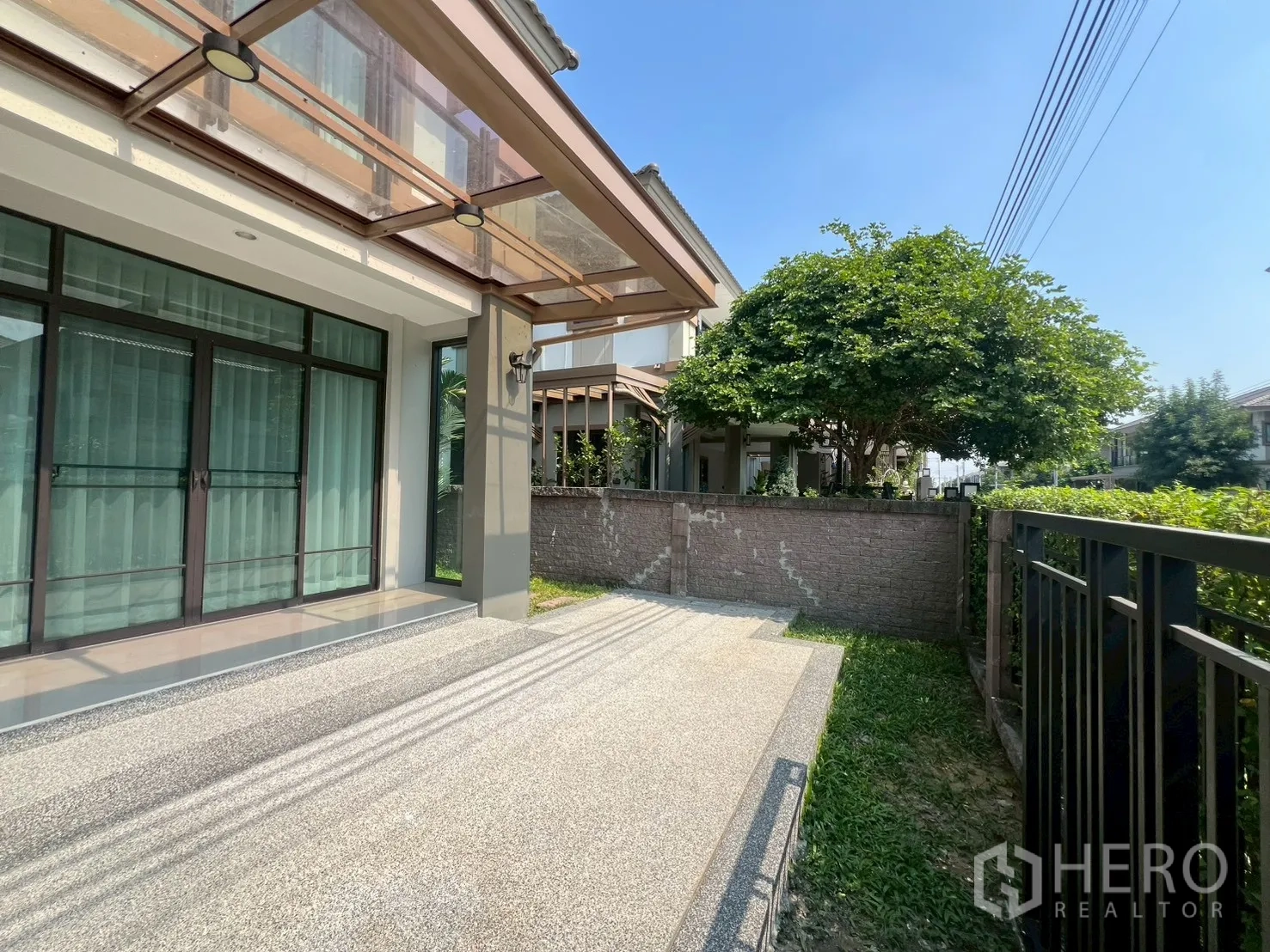 Detached House for rent or sale in Bang Phli, Samut Prakan - Front patio with canopy, sliding glass doors and small lawn.