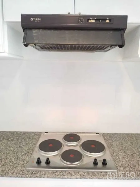 Condominium for rent in Sathon, Bangkok - Electric four-burner cooktop with range hood on granite counter.