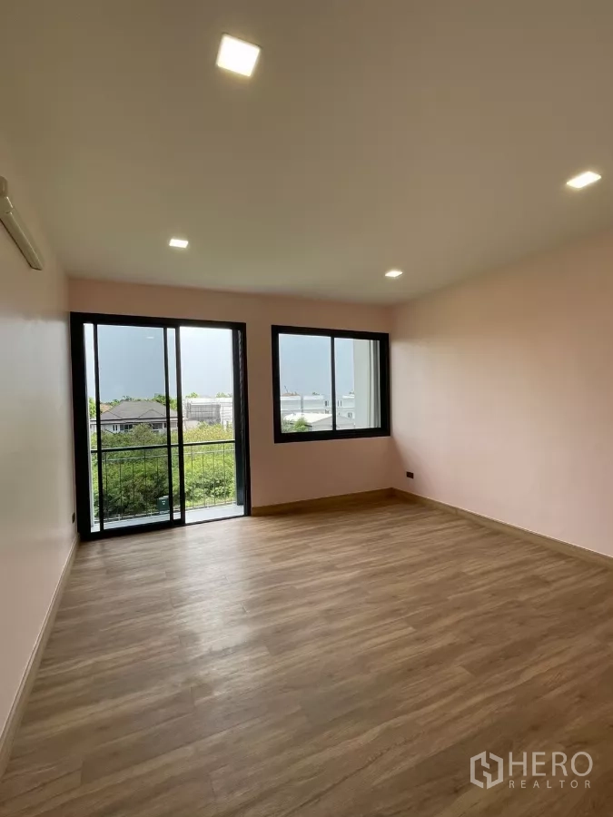 Home Office for rent in Khan Na Yao, Bangkok - Corner bedroom with pastel wall, balcony access and garden outlook.