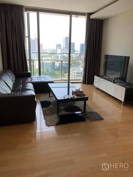 คอนโด ให้เช่าในWatthana, Bangkok - ห้องนั่งเล่นสว่าง โซฟาหนัง ทีวี และหน้าต่างกระจกเต็มบานวิวเมือง