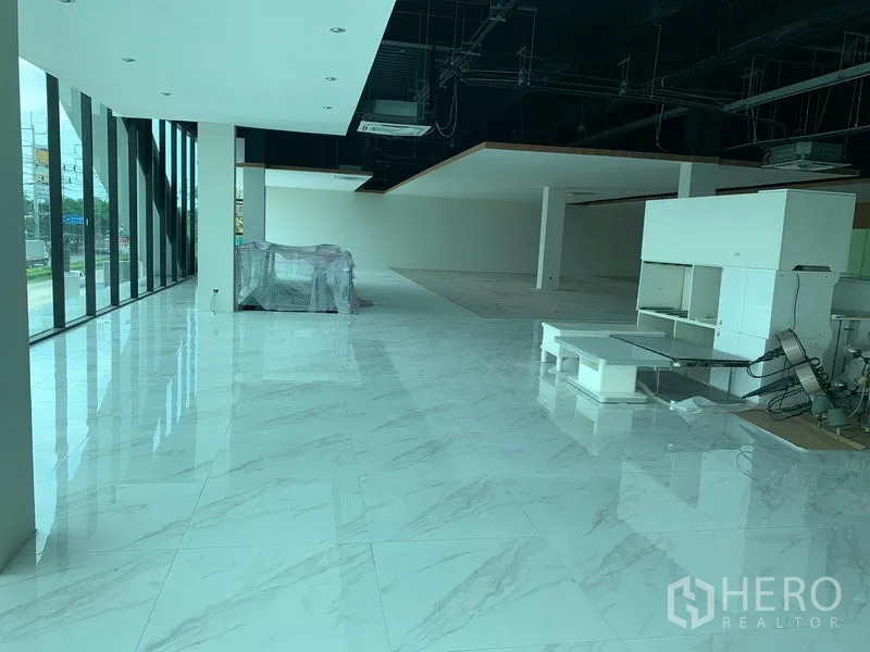 Retail Space for rent in Lam Luk Ka, Pathum Thani - Sunlit showroom area with floor-to-ceiling glass frontage and polished tile flooring.