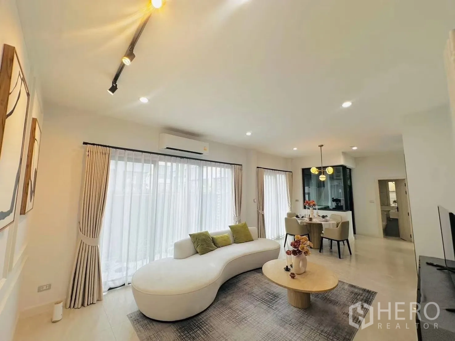 ทาวน์เฮาส์ for rent in Suan Luang, Bangkok - พื้นที่นั่งเล่นและทานอาหารแบบโอเพ่นแปลน โซฟาทรงโค้ง โต๊ะกลม และประตูกระจกสูง
