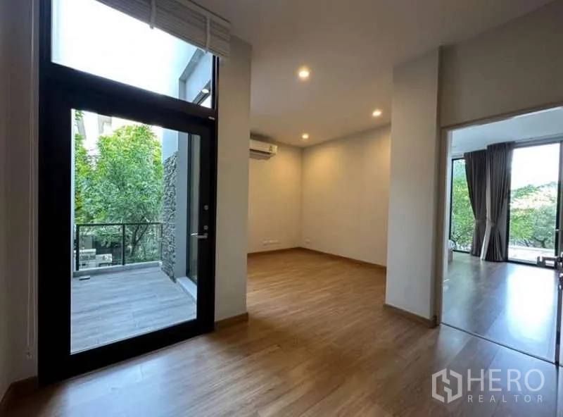 联排别墅 出租在Lat Phrao, Bangkok - 楼上家庭区，连通小露台，木地板与筒灯照明。