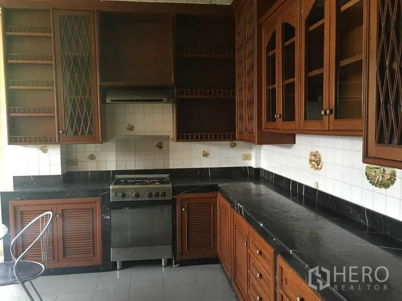 ทาวน์เฮาส์ ให้เช่าในKhlong Toei, Bangkok - ครัวรูปตัวแอล เตาและเครื่องดูดควัน พร้อมตู้เก็บของไม้จำนวนมาก