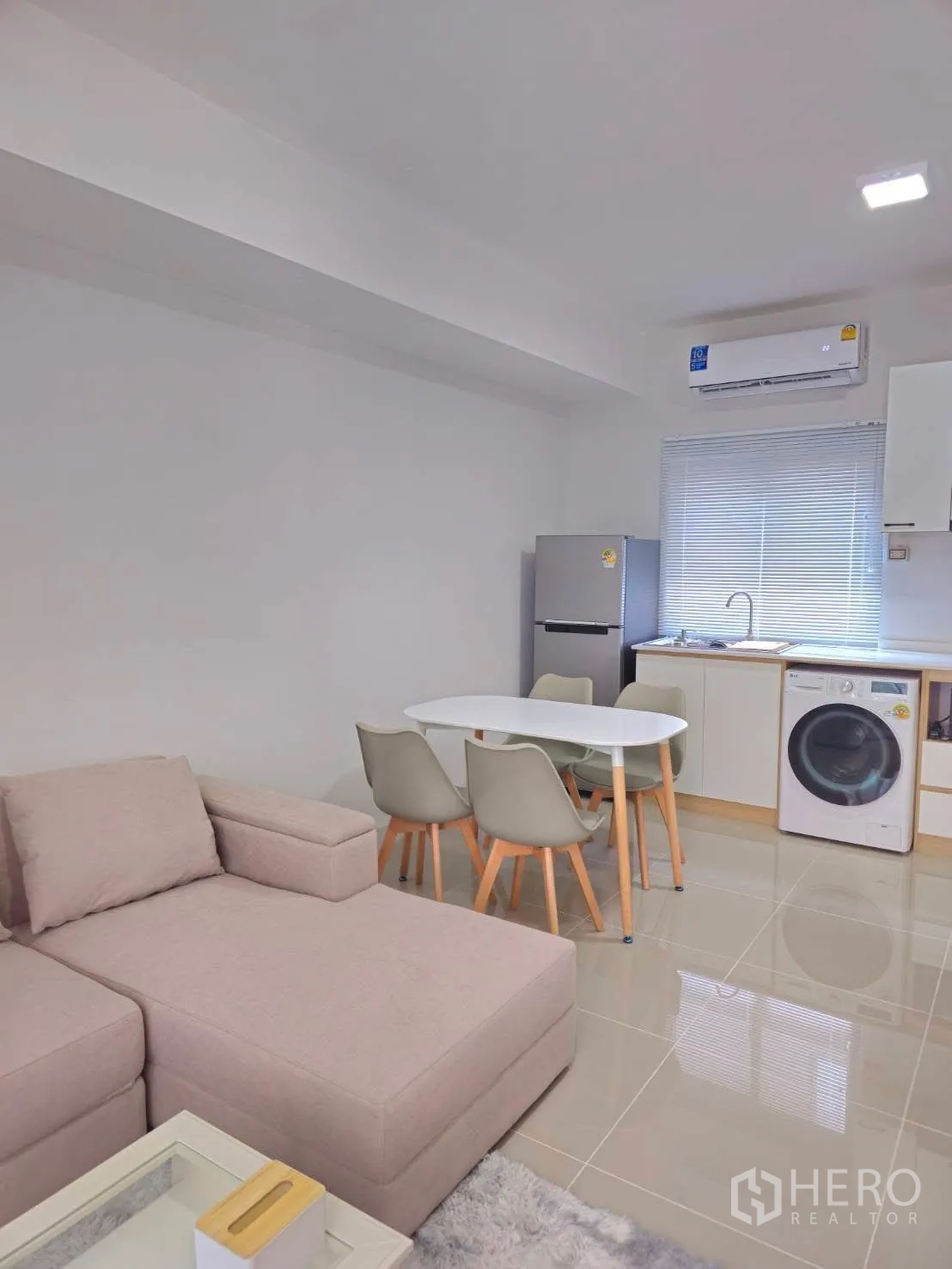 Townhouse for rent in Bang Phli, Samut Prakan - Open-plan living, dining and kitchen with sofa, table, fridge and washing machine.