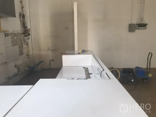 零售空间 出租在Khlong Toei, Bangkok - 后场区域带白色操作台，给排水与管线已到位，适合轻餐饮装修。