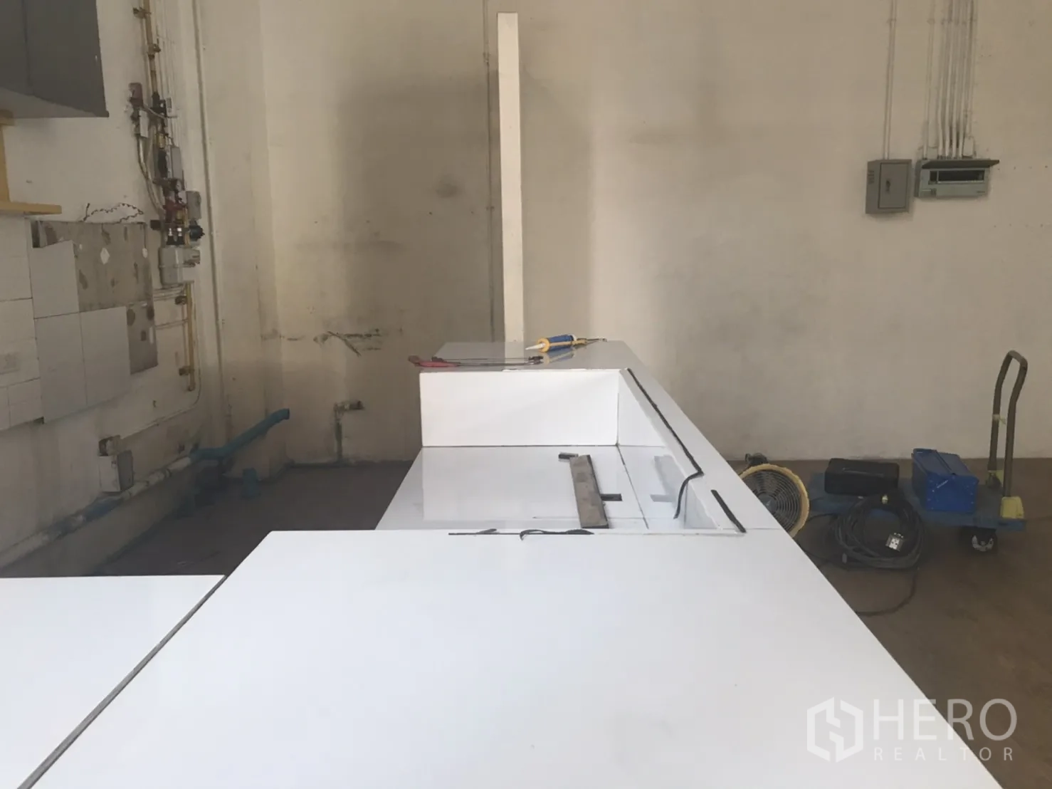 零售空间 出租在Khlong Toei, Bangkok - 后场区域带白色操作台，给排水与管线已到位，适合轻餐饮装修。