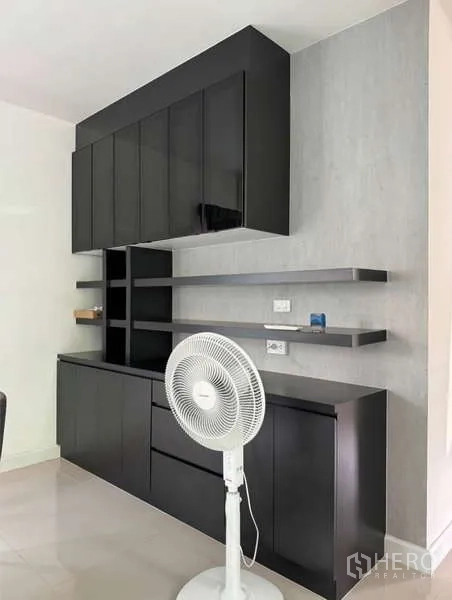 Detached House for rent in Bueng Kum, Bangkok - Built-in black storage cabinets and floating shelves in the living area.