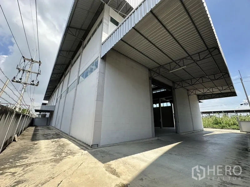 工厂 出租在Lam Luk Ka, Pathum Thani - 建筑后侧车道与装卸区，连接深檐雨棚。