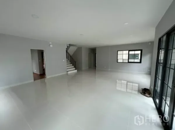 独立式住宅 出租在Bang Phli, Samut Prakan - 宽敞开放式客餐厅，亮面瓷砖地、楼梯与大窗及推拉门。