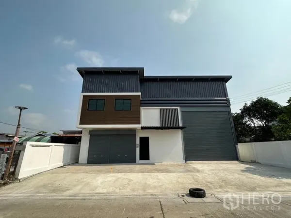 货栈 出租在Lam Luk Ka, Pathum Thani - 两层新仓库正面全景，双卷闸门与宽阔前院停车区，Lam Luk Ka