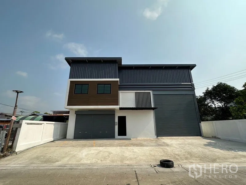 货栈 出租在Lam Luk Ka, Pathum Thani - 两层新仓库正面全景，双卷闸门与宽阔前院停车区，Lam Luk Ka
