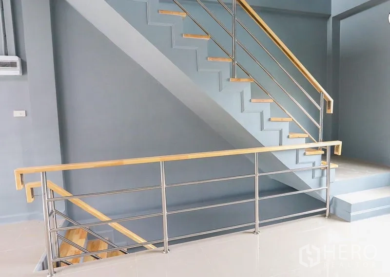 Shophouse for sale in Lam Luk Ka, Pathum Thani - Upper landing with steel balustrade connecting the shophouse floors.