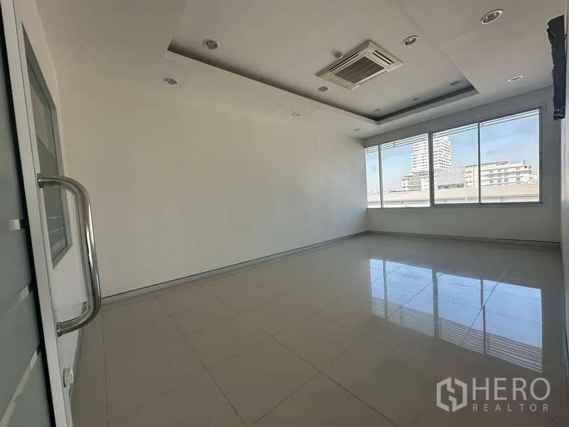 Office Space for rent in Prawet, Bangkok - Bright private office room with tiled floors, recessed lighting and a wide window view.