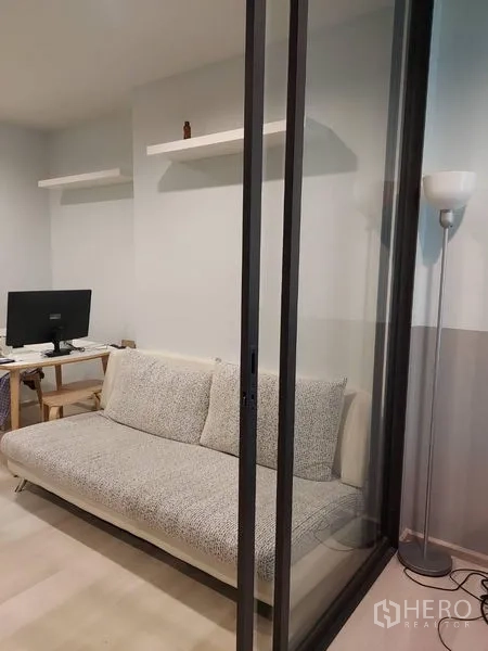 公寓 出售 - 玻璃隔断后的沙发，落地灯与简约书桌，形成小型家办公区。