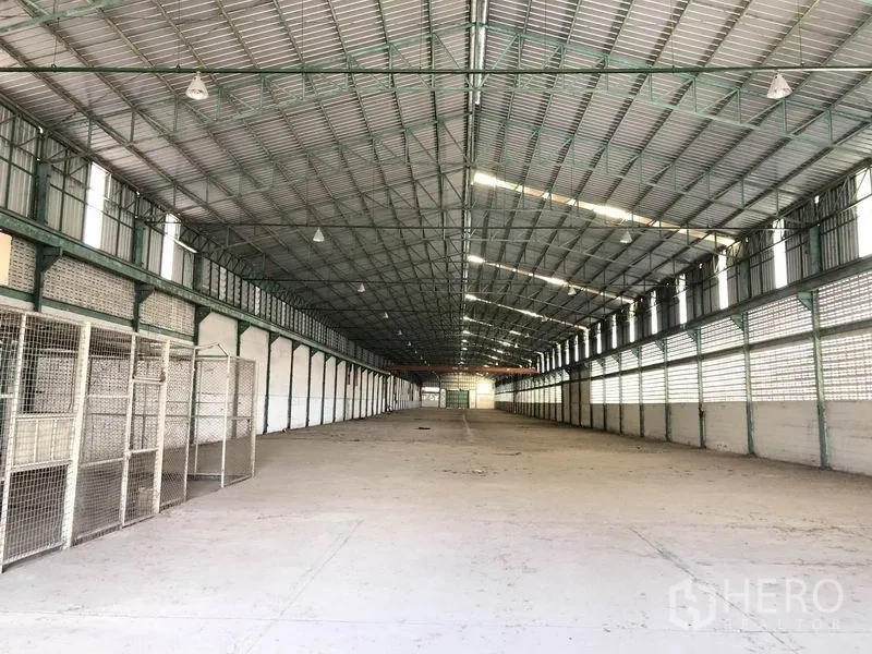 Warehouse for rent in Samut Prakan - Long clear-span storage hall with ventilated block walls and concrete flooring.