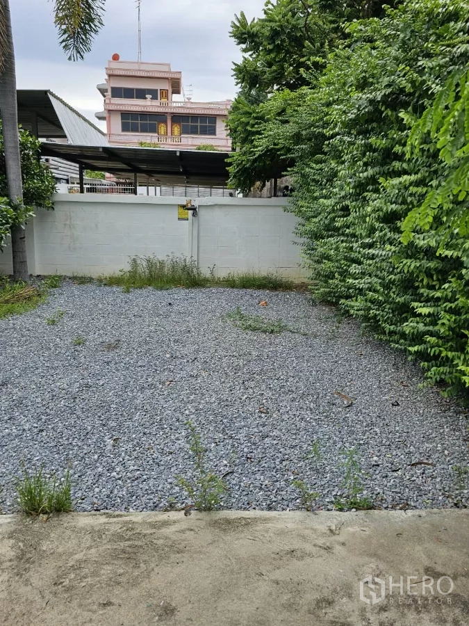 บ้าน ให้เช่าหรือขายในLat Phrao, Bangkok - พื้นที่จอดรถโรยหินกรวดติดประตูรั้วด้านหลัง รายล้อมด้วยต้นไม้