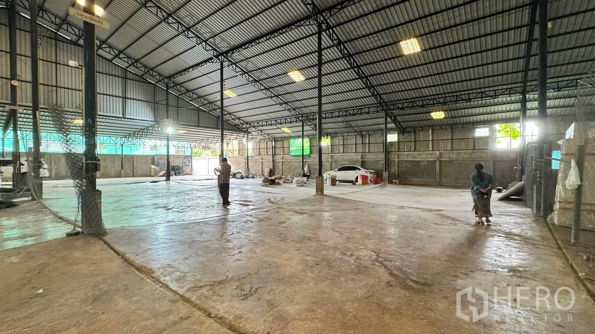 Warehouse for rent in Bang Khen, Bangkok - Open storage space with steel columns and chain-link partitions inside the warehouse.