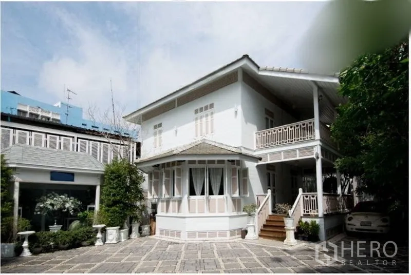 Detached House for rent in Bang Rak, Bangkok - Wide view of a two-storey detached house with paved courtyard and car parking.