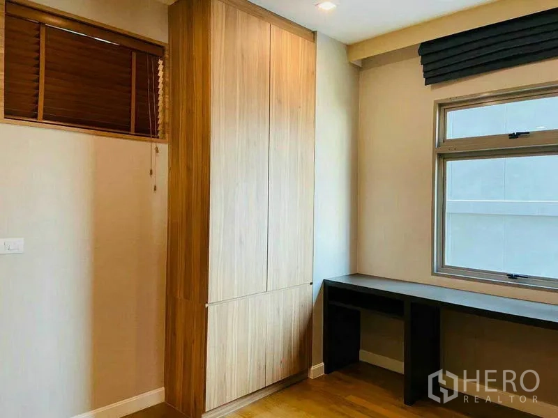 Condominium for rent in Watthana, Bangkok - Corner space with tall wood wardrobe and a study desk under the window.