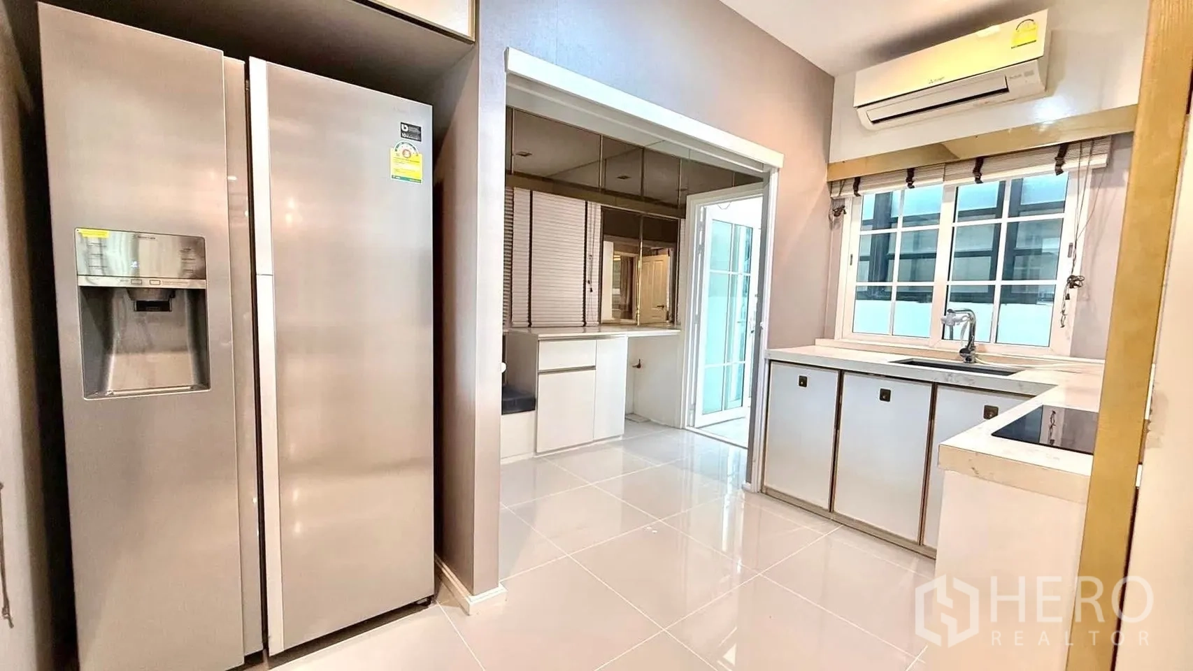 Detached House for rent or sale in Bueng Kum, Bangkok - Kitchen with double-door fridge, white cabinetry, tiled floor and a window over the sink.
