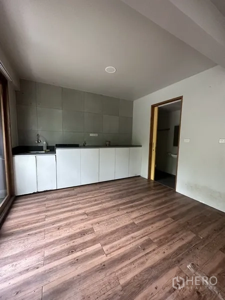 带办公室的家 出租在Watthana, Bangkok - 茶水间，带水槽、白色柜体与木地板。