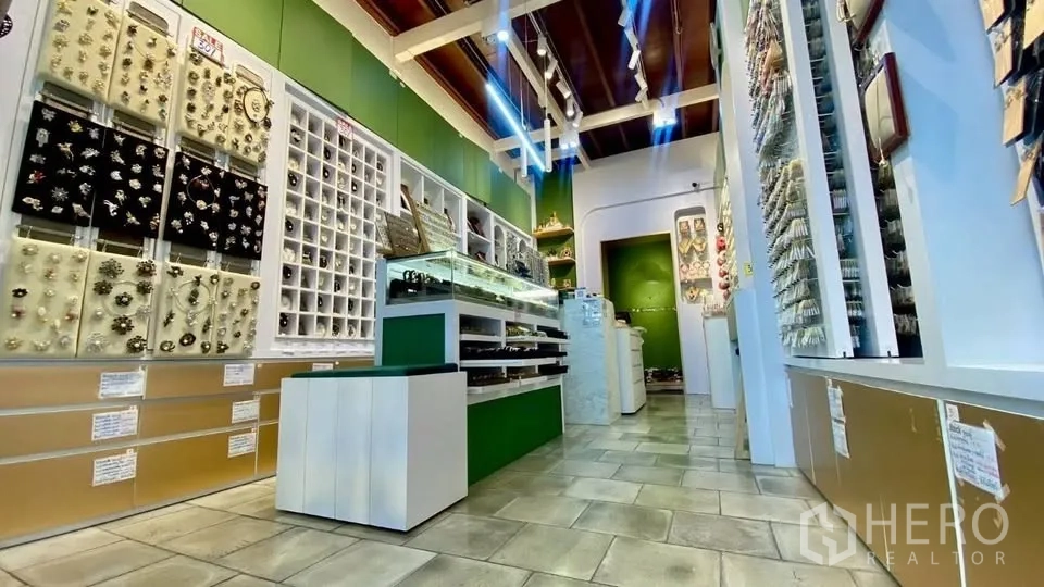 零售空间 出租在Samphanthawong, Bangkok - 店内铺有瓷砖地面，玻璃展柜与墙面陈列架，射灯照明。