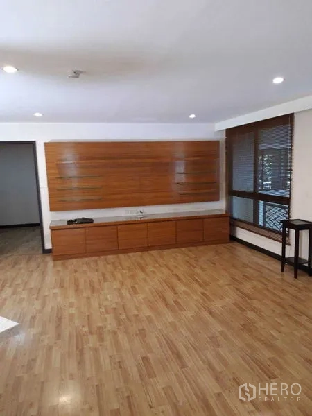 Condominium for sale - Open living space featuring media wall cabinet and corner windows.