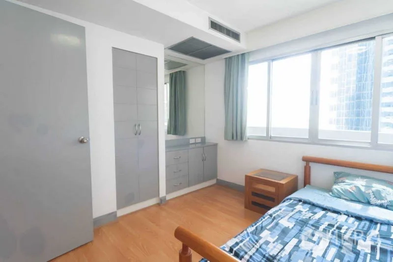 Condominium for rent in Ratchathewi, Bangkok - Bright bedroom with built-in wardrobe, dressing corner and large window.
