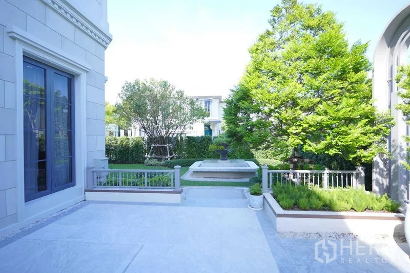 Detached House for sale in Bang Kapi, Bangkok - Private courtyard with stone terrace, fountain, and mature trees.