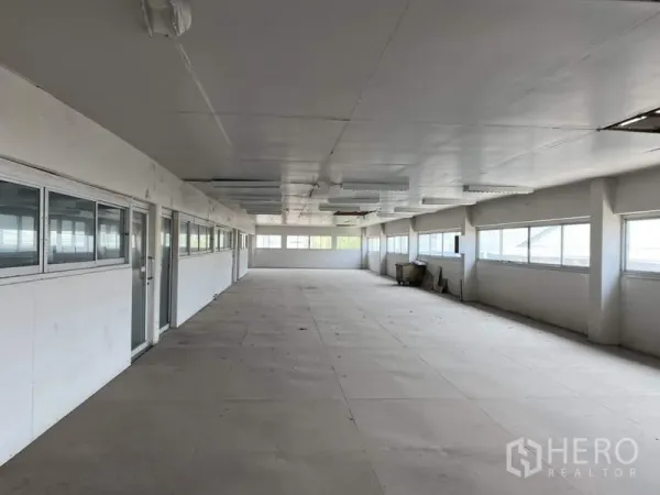 Factory for sale in Khlong Luang, Pathum Thani - Spacious upper-floor office area with rows of windows and bright tiled flooring.