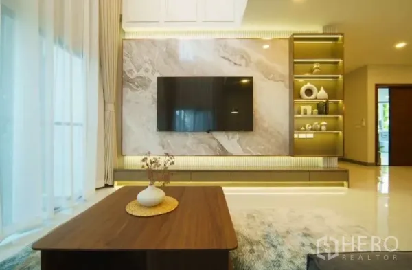 Detached House for rent or sale in Bang Phli, Samut Prakan - Feature TV wall with marble panel, illuminated built-in shelves and a wooden coffee table.