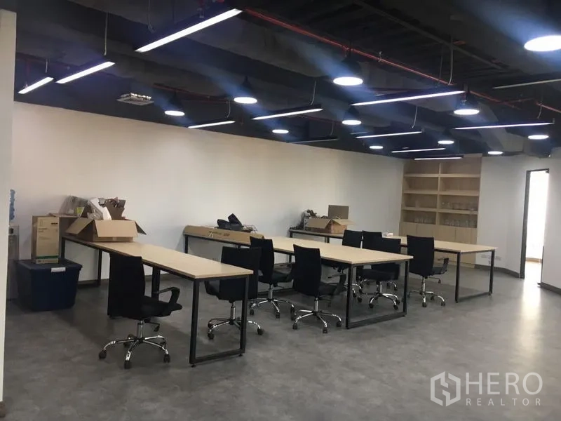 Office Space for rent in Sathon, Bangkok - Open-plan workspace featuring long desks, task chairs, shelving and linear LED lights.