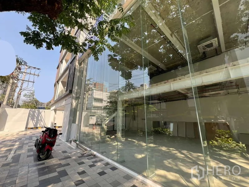 พื้นที่ขายปลีก ให้เช่าในWatthana, Bangkok - มุมถนนโชว์หน้าร้านกระจกบานใหญ่ เห็นพื้นที่โล่งและชั้นลอยภายใน