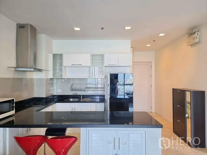 Condominium for rent in Khlong Luang, Pathum Thani - Bright fitted kitchen with island, glass backsplash, hood and double‑door fridge.
