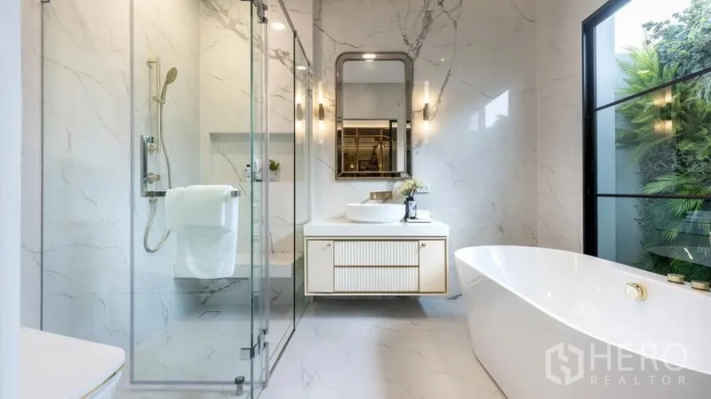 Detached House for rent or sale in Saphan Sung, Bangkok - Spa-style bathroom with rainfall shower, soaking tub and garden-view window.