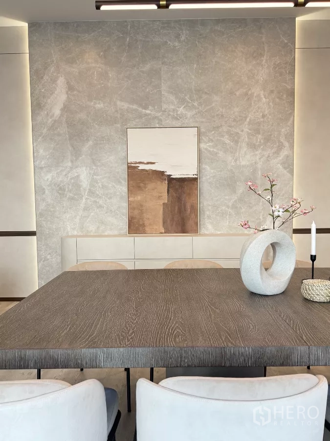 Detached House for rent in Saphan Sung, Bangkok - Close-up of a modern dining table with a sculptural vase against a stone-textured feature wall.